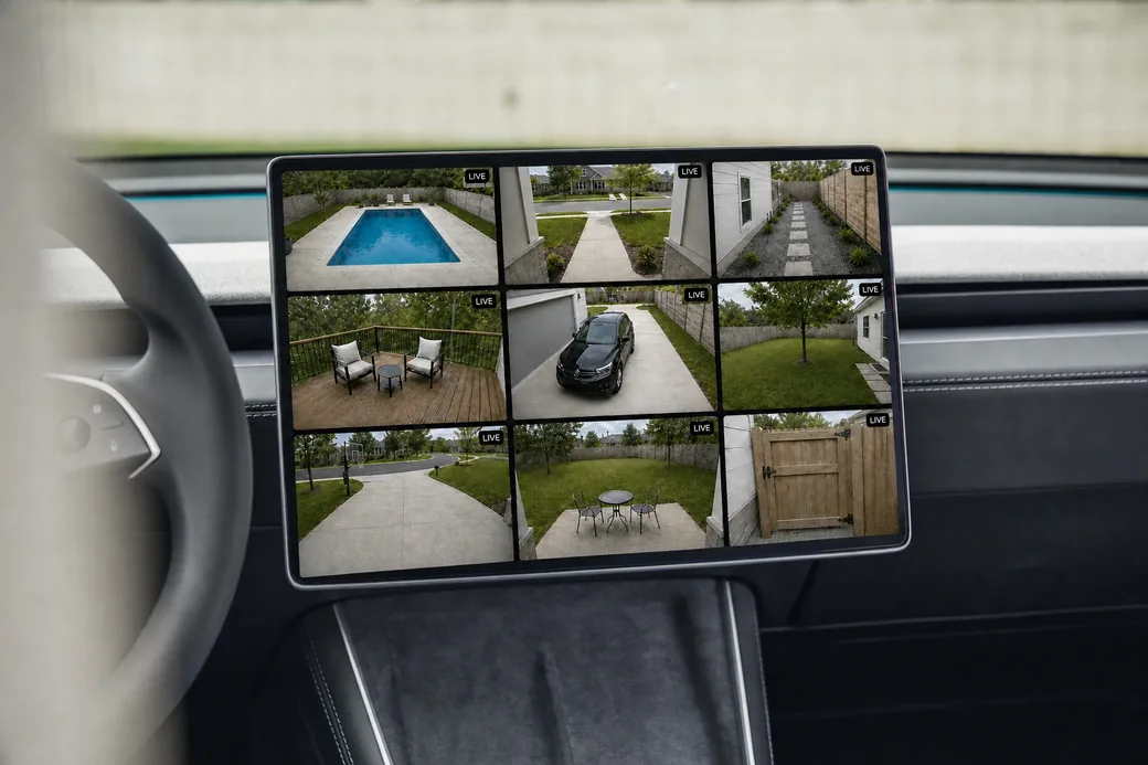 A car's dashboard touchscreen showing nine Ring cameras live in a grid